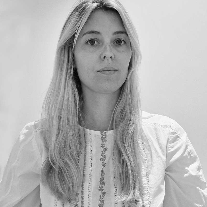 Femme blonde, portrait monochrome en chemisier brodé. Femme blonde aux cheveux longs portant un chemisier blanc brodé de motifs floraux. Portrait sérieux en noir et blanc.