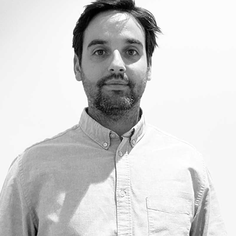 Portrait professionnel homme barbu en noir et blanc Portrait professionnel en noir et blanc d'un homme à la barbe courte et aux cheveux sombres, regard direct et confiant, portant une chemise.