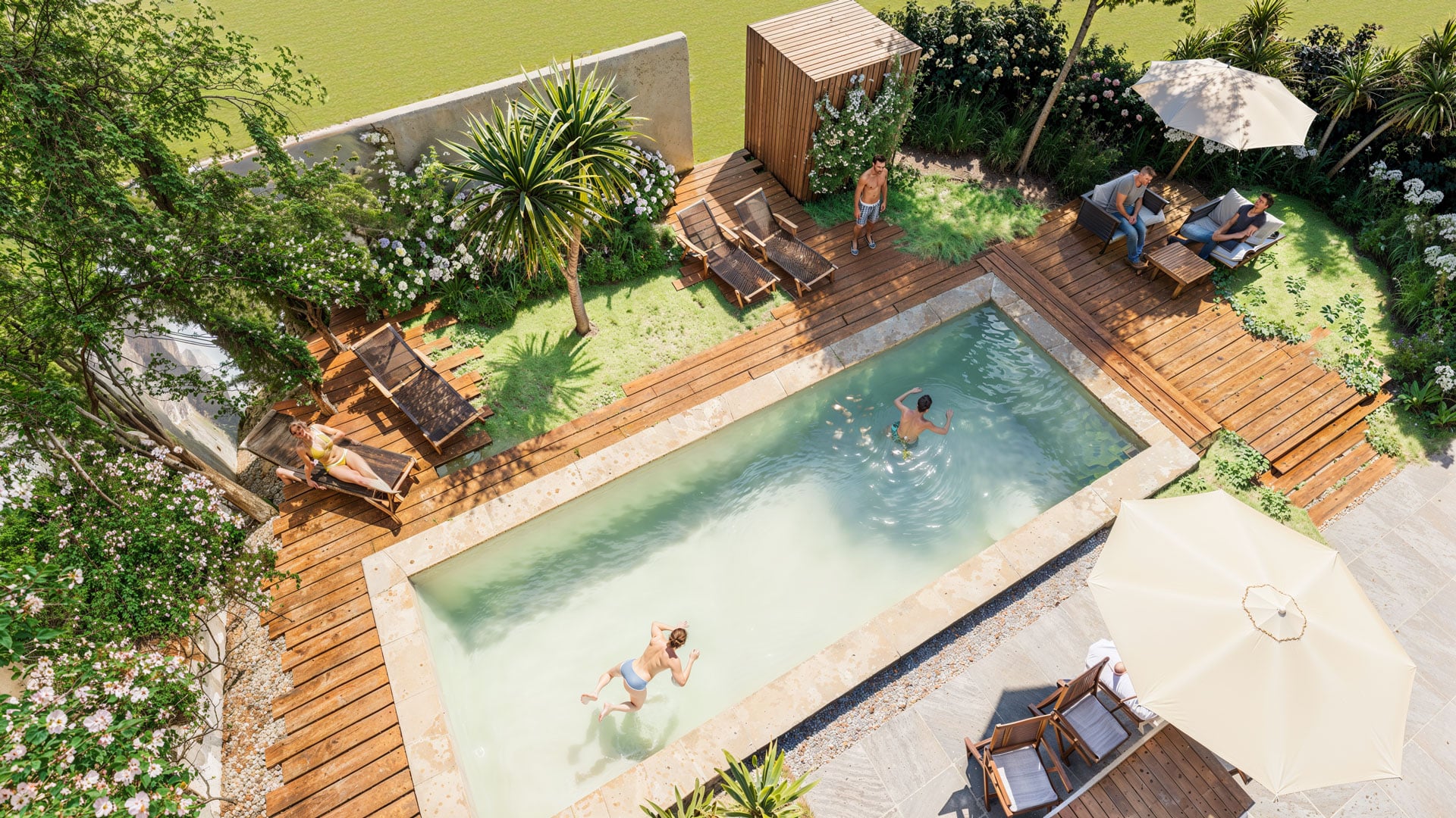 Personnes profitant d'une piscine rectangulaire dans un jardin paysager avec terrasse en bois et chaises longues.