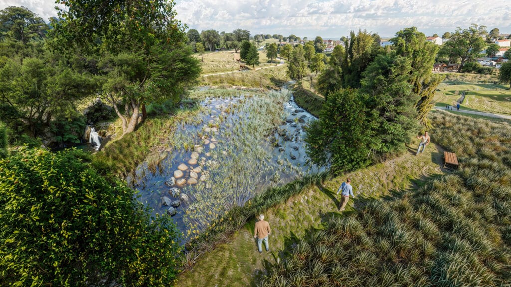 Paysage verdoyant avec ruisseau, cascade et randonneurs Trois randonneurs sur un sentier surplombant un ruisseau clair et une cascade dans un paysage verdoyant ensoleillé.