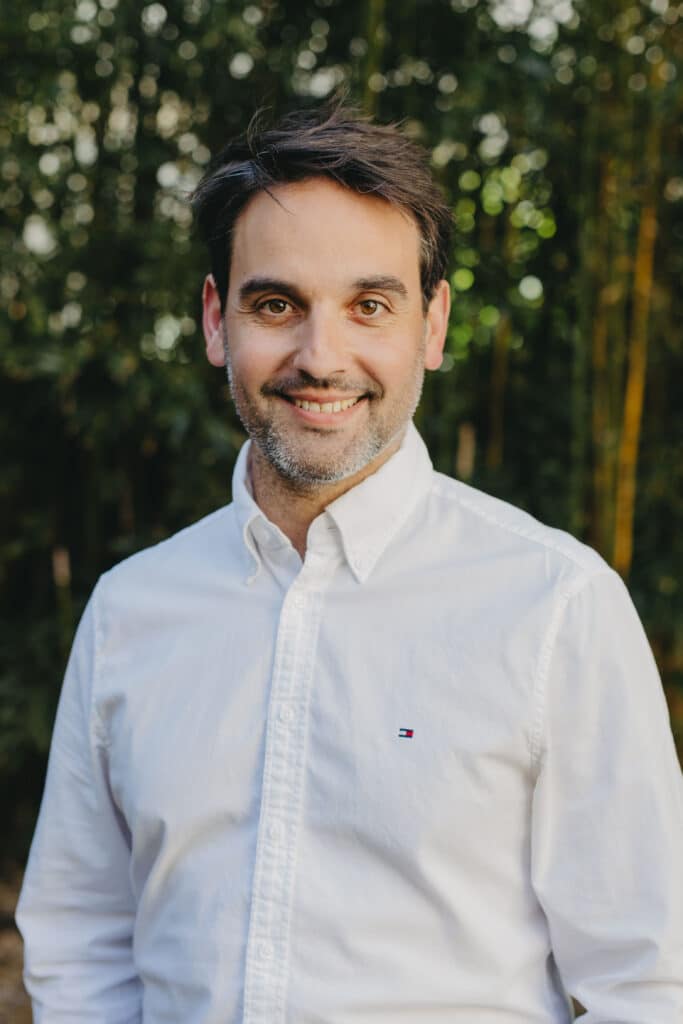 Portrait professionnel homme souriant en chemise blanche Homme souriant avec barbe légère en chemise blanche Tommy Hilfiger sur fond de nature flou.