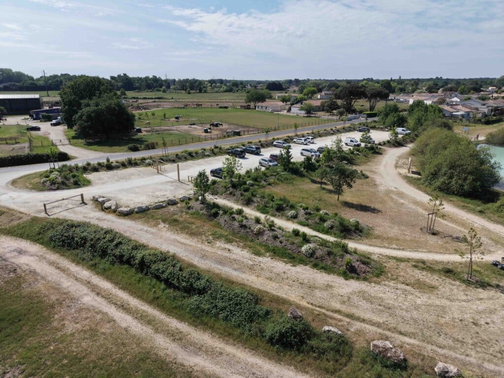 Aménagement de Parking Paysager Naturel : Vue Aérienne Parking paysager rural avec sentiers et végétation vu du ciel.