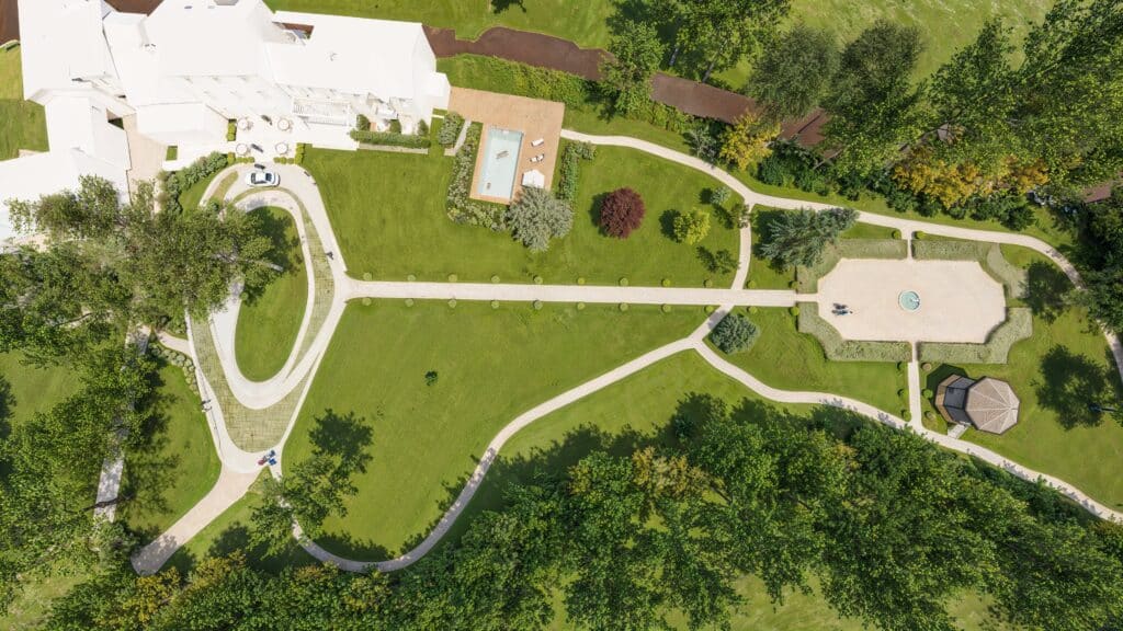 Propriété de luxe avec jardin paysager vu du ciel Vue aérienne d'une villa blanche, piscine et jardin paysager avec allées sinueuses et gazebo.