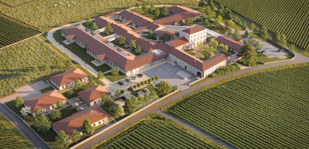 Architecture de Domaine Viticole Entouré de Vignes Domaine viticole aux toits rouges entouré de vignobles verdoyants en vue aérienne ensoleillée.